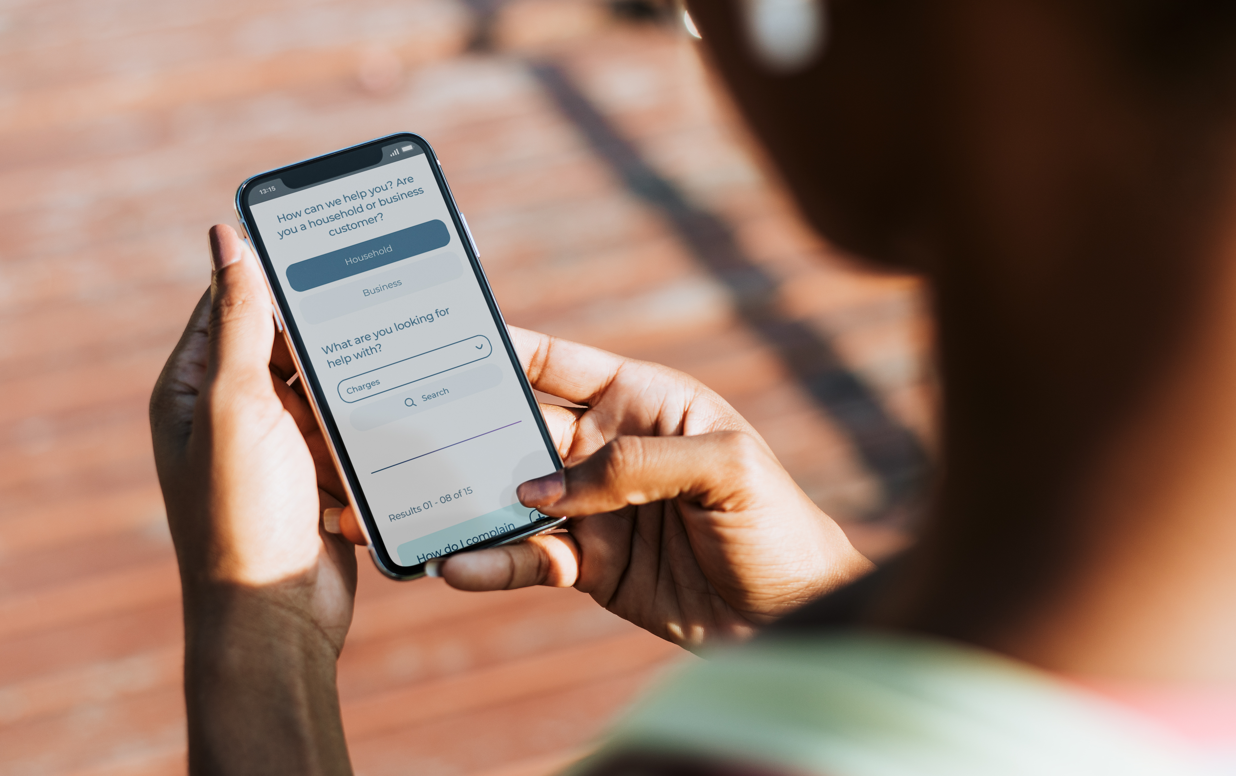 Woman outdoors holding her mobile phone with the CCW FAQs on screen