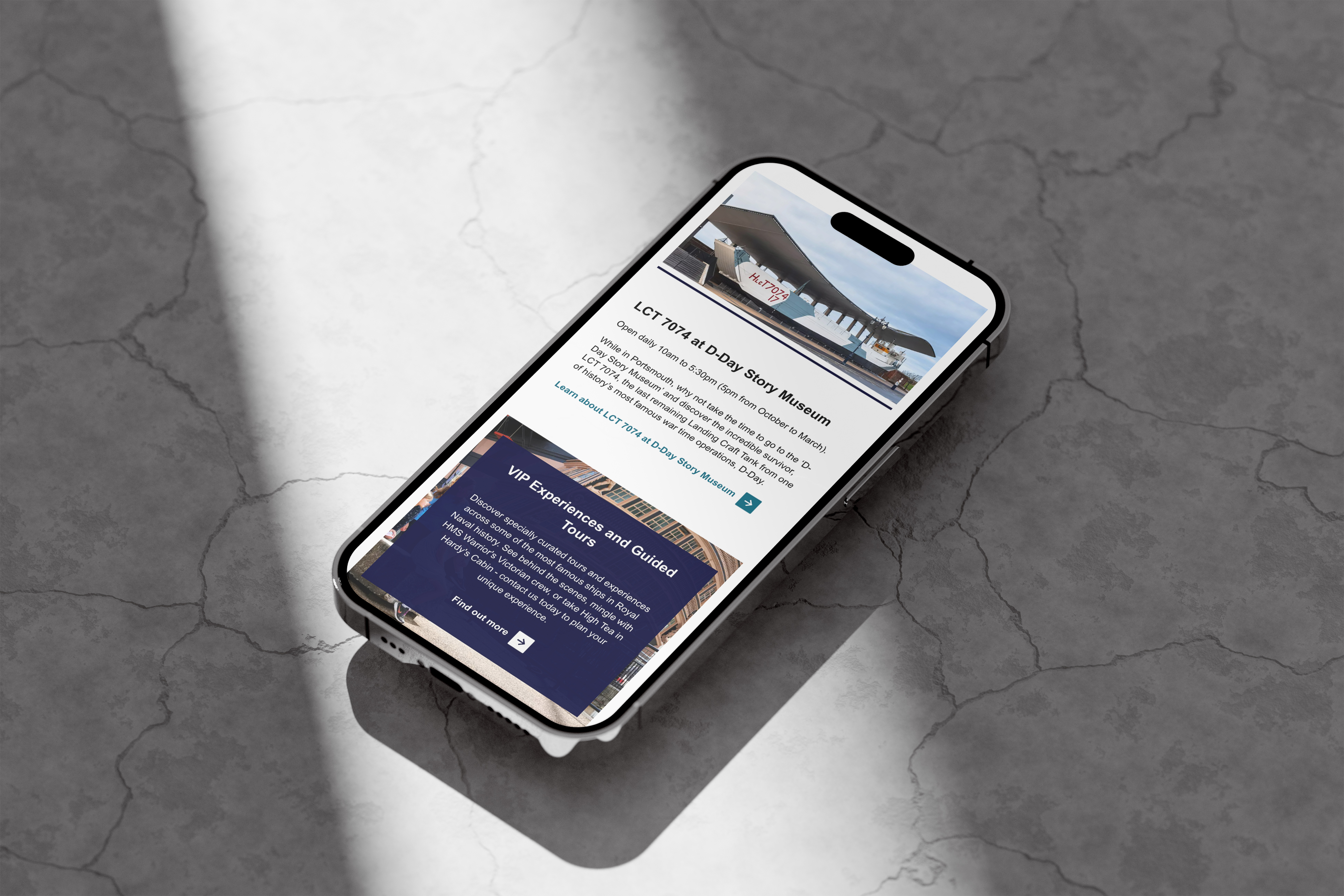 iPhone on concrete surface with the NMRN website on screen
