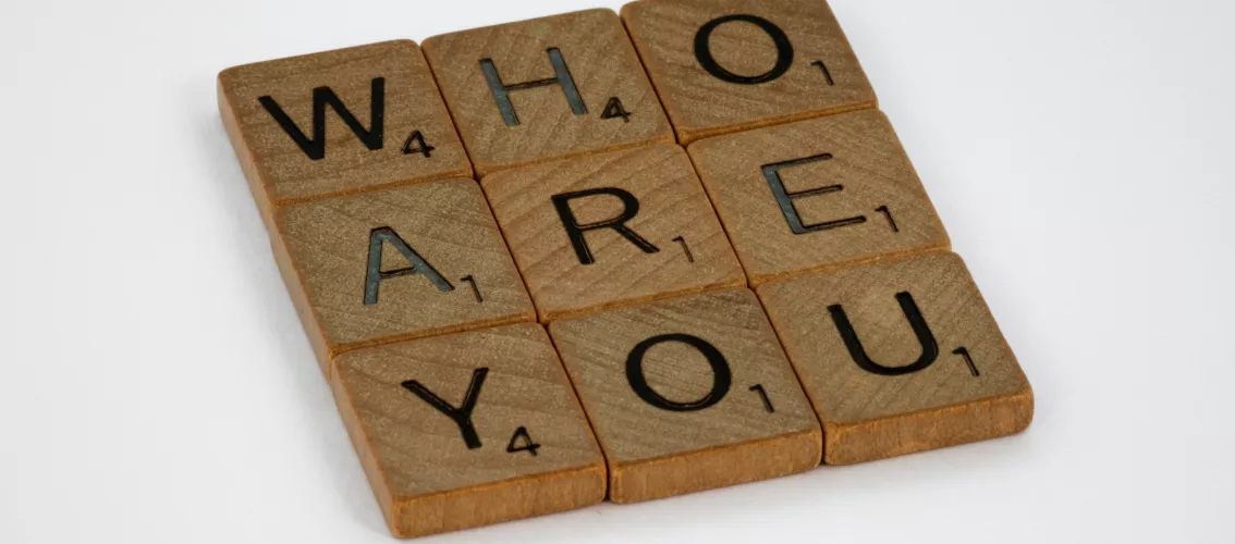 Scrabble tiles forming the words "Who are you".