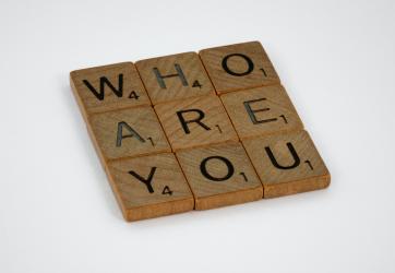 Scrabble tiles forming the words "Who are you".
