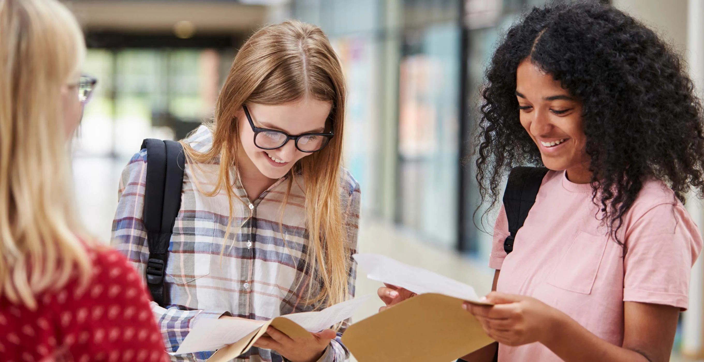 Three high school girls opening their exam results